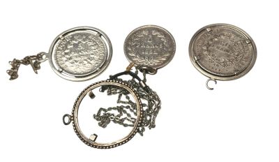 plusieurs types de bijoux en argent, dont une pièce de monnaie et un collier