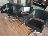 three black chairs sitting in a row in front of a mirror