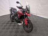 une photo d'une moto rouge garée dans un garage