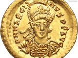 a close up of a gold coin with a woman on it