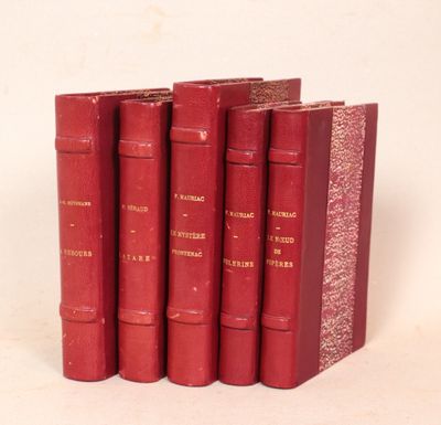 quatre livres rouges sont empilés les uns sur les autres sur une surface blanche