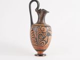 a vase that is sitting on a stand on a white surface