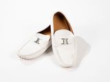 a pair of white loafers with a monogram on the front