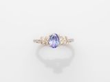an oval tanzane and diamond ring on a white background