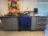 a blue and gray printer sitting on a desk in a room