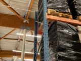 une grande pile de sacs noirs posée sur une étagère dans un entrepôt