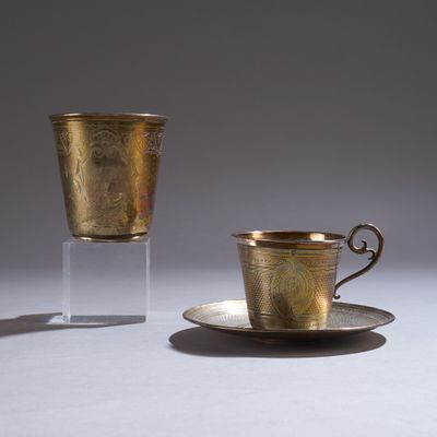 a cup and saucer sitting on a table next to each other