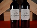 two bottles of wine sitting next to each other on a table
