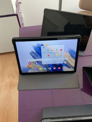 deux ordinateurs portables posés sur une table violette