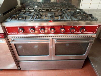 une cuisinière rouge à quatre feux dans une cuisine