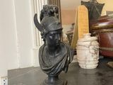 a statue of a woman sitting on a shelf next to a mirror
