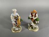 two figurines of a man and a woman sitting on a rock