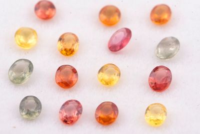 un assortiment de pierres précieuses de différentes couleurs posées sur une surface blanche