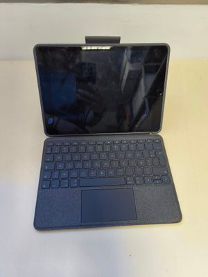 un ordinateur portable ouvert posé sur une table blanche