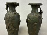 deux vases verts posés l'un à côté de l'autre sur une table