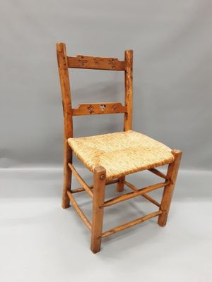 une vieille chaise en bois avec une assise tressée sur fond blanc