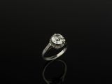 a single stone diamond ring on a black surface