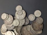 a pile of silver coins on a black surface