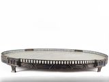 an oval metal tray with a decorative design on the top