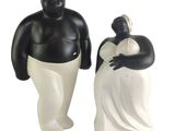 two figurines of a man and a woman standing next to each other