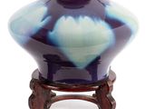 un vase bleu et blanc posé sur un support en bois