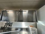 une cuisine avec des placards en inox et des couteaux posés sur le plan de travail