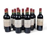 six bottles of red wine lined up in a row on a white surface