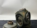 an old gas mask and a gas canister on a table