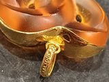 a close up of a gold colored object on a black surface