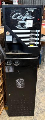 a black refrigerator with a sign on it in a warehouse