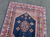 an antique persian rug with a blue background and a floral design