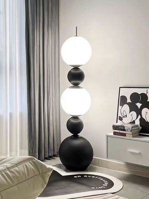 un salon avec un canapé blanc et une lampe noire et blanche