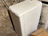 a white washing machine sitting next to a pile of boxes