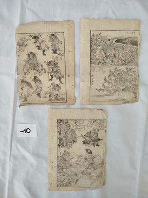 trois vieux livres illustrés, posés sur une surface blanche