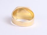 a close up of a gold ring on a white surface