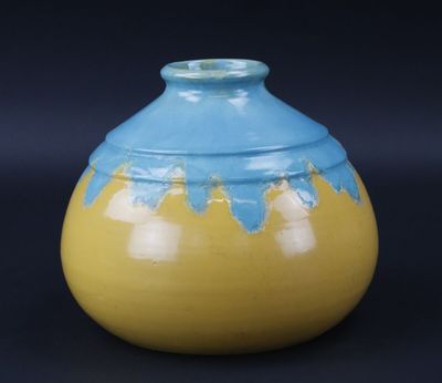 un vase jaune et bleu sur fond noir