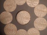 a circle made out of old papers with a coin in the middle