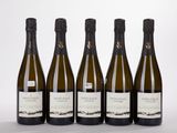 four bottles of wine are lined up on a white surface