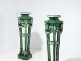 deux vases verts posés l'un à côté de l'autre sur une table