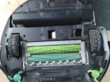a robot that is sitting on the floor with a green cord