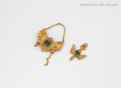 two pieces of gold and emerald jewelry on a white surface