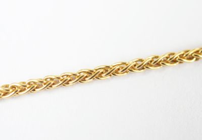 a close up of a gold chain on a white surface