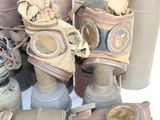 many different types of gas masks sitting on a table