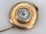a gold pocket watch with a chain around it
