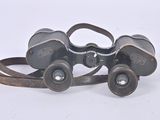 an old pair of binoculars sitting on top of a white surface