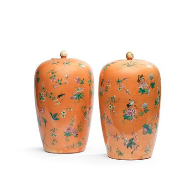 une paire de vases orange ornés d'oiseaux et de fleurs sur un fond blanc