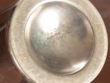 a silver vase sitting on top of a wooden table