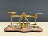 an antique brass scale on a wooden base with a black background