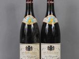 two bottles of wine sitting on top of a table next to each other