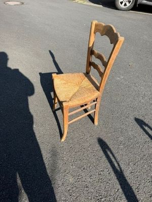 une chaise en bois posée au milieu d'un parking